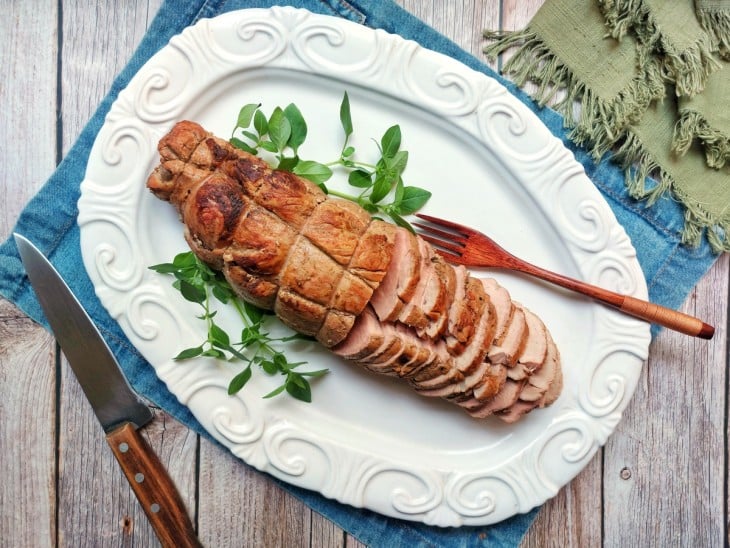 Rosbife suíno servido em recipiente de cor branca.