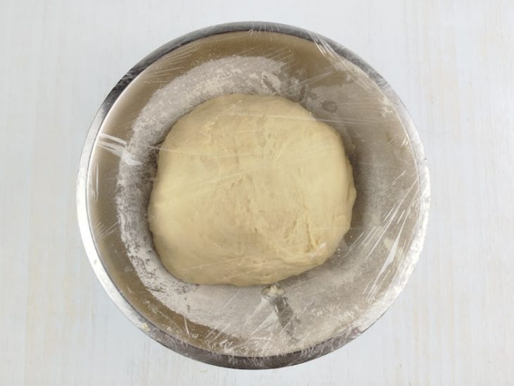 Massa modelada na tigela com farinha.