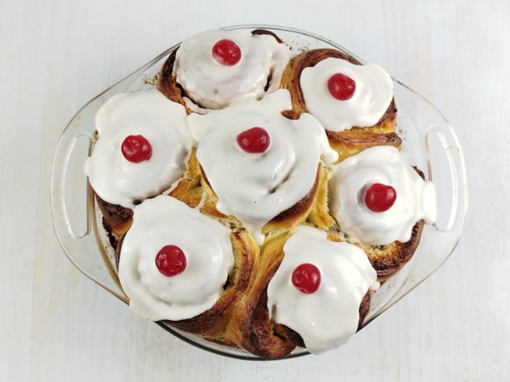 Cobertura e cerejas despejadas sobre a rosca.