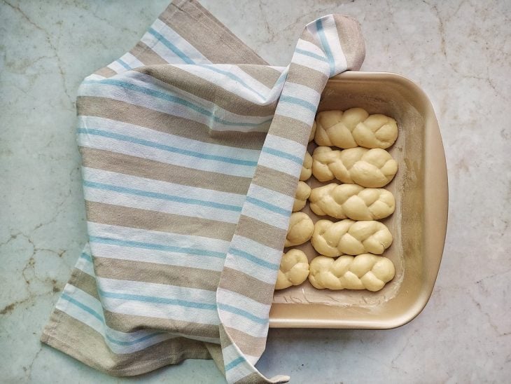 Rosquinhas numa assadeira coberta por pano.