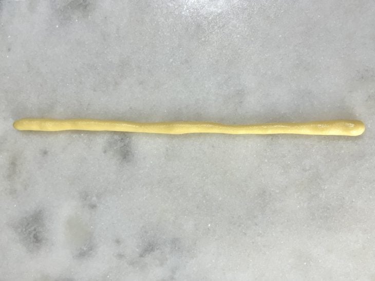 Uma bancada com a massa esticada para formar a rosquinha.
