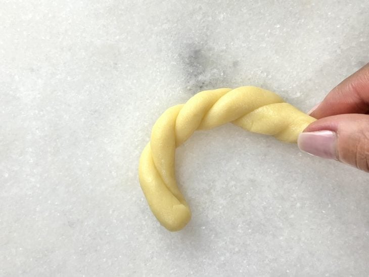 Uma tirinha de massa enrolada para formar a rosquinha.