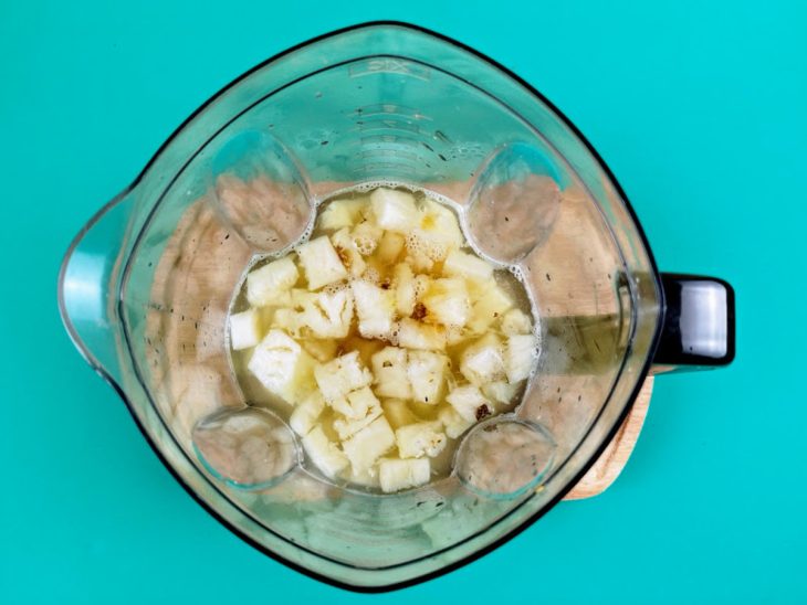 Chá, abacaxi, rum, hortelã, mel e suco de limão adicionados ao liquidificador.
