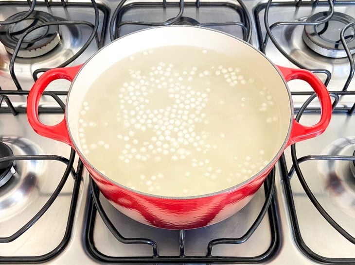 Uma panela ao fogo com água e sagu.