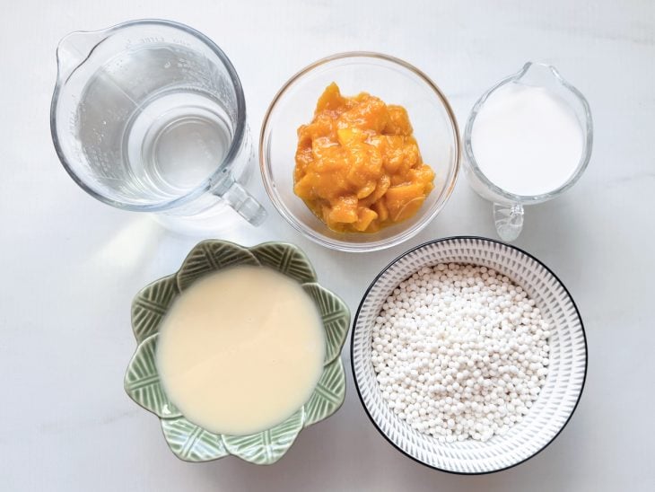 Ingredientes organizados na bancada com sagu, manga e demais itens separados.