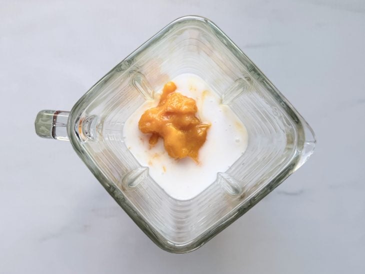Manga sendo batida no liquidificador com leite condensado e leite de coco.