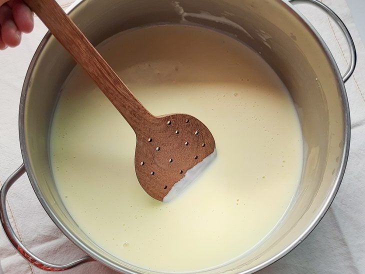 Uma panela cozinhando creme branco doce.