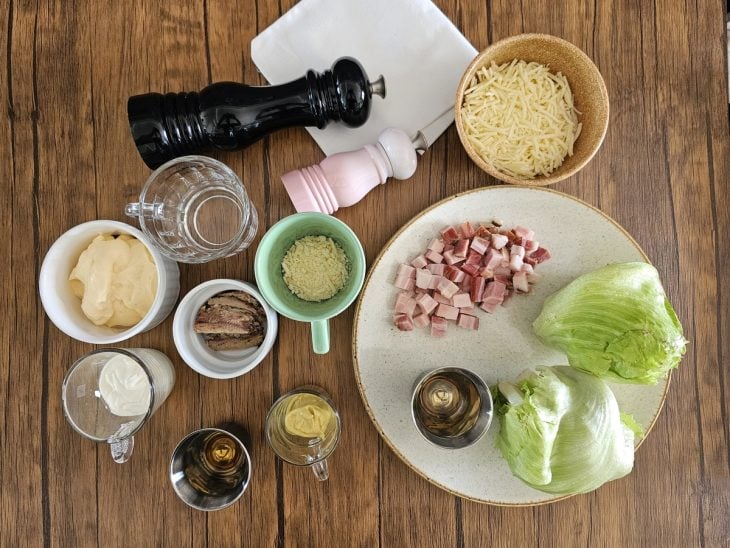 Ingredientes da salada caesar com crispy de queijo reunidos na bancada.