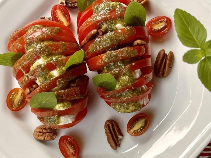 Um recipiente contendo salada caprese com pesto.