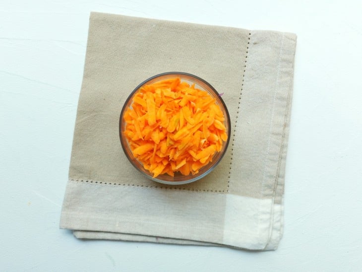 Um recipiente contendo cenoura ralada.