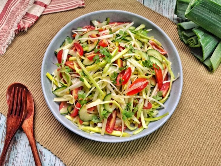 Um prato contendo salada de alho-poró com pepino e tomate.