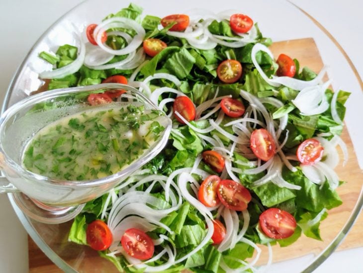 Um recipiente contendo salada de almeirão.