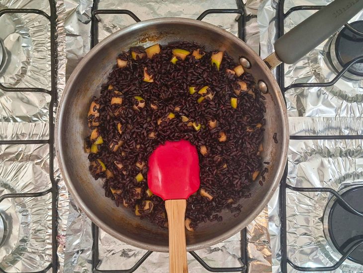 Arroz sendo misturado à maçã caramelizada.