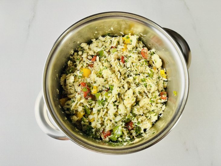Bacalhau, coentro e vinagre sendo adicionados ao refogado.