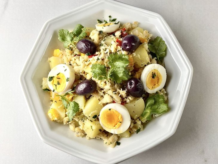 Salada finalizada com ovos fatiados e azeitonas pretas.