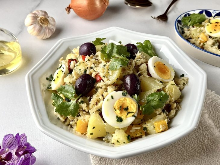 Salada de bacalhau com batata e ovo servida no prato.