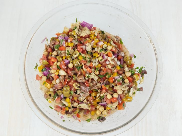 Salada sendo temperada com azeite, sal e pimenta.