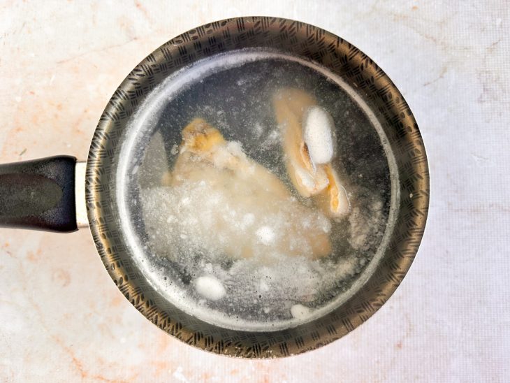 Na panela, bacalhau cozinhando.