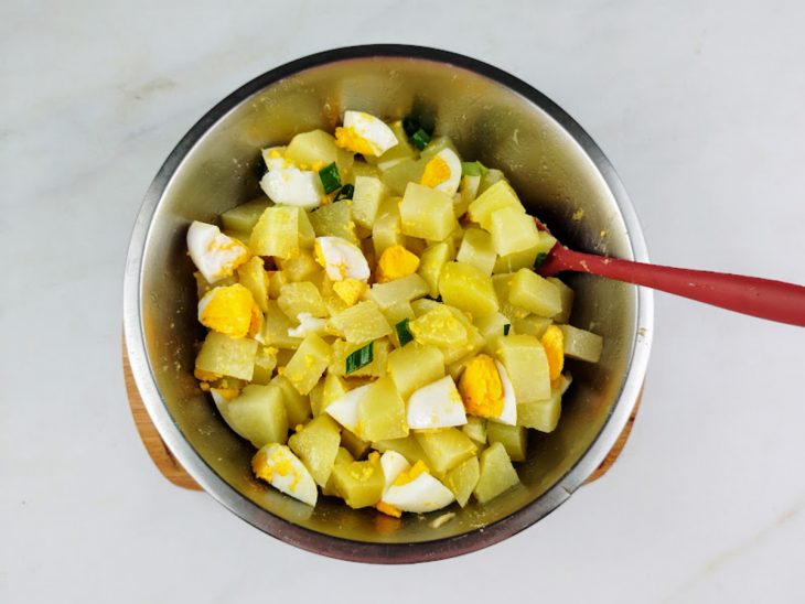 Cebolinha e sal adicionados às batatas e aos ovos cozidos.