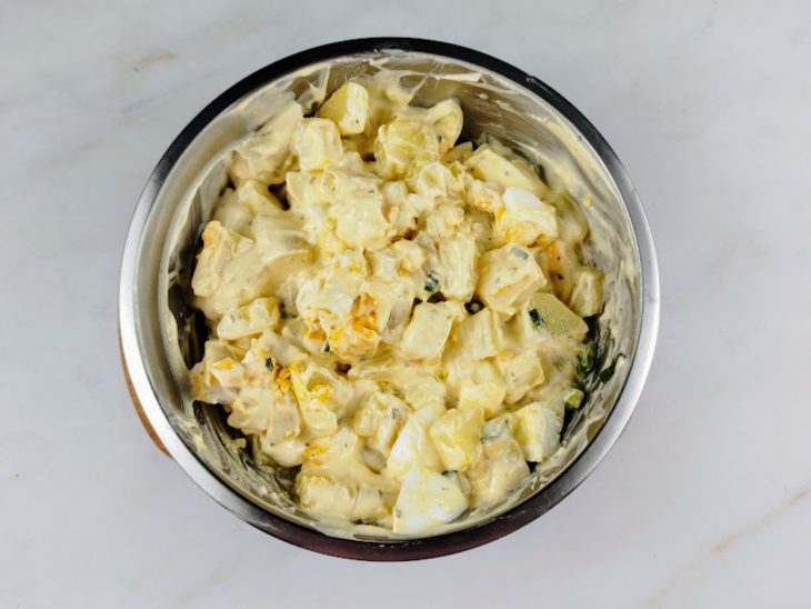 Molho despejado sobre as batatas e os ovos.