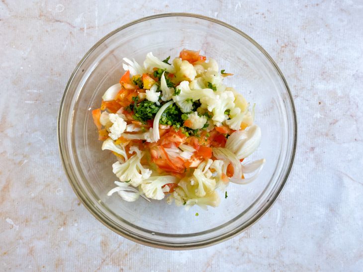 Tomate, cebola e cheiro-verde adicionados a tigela.