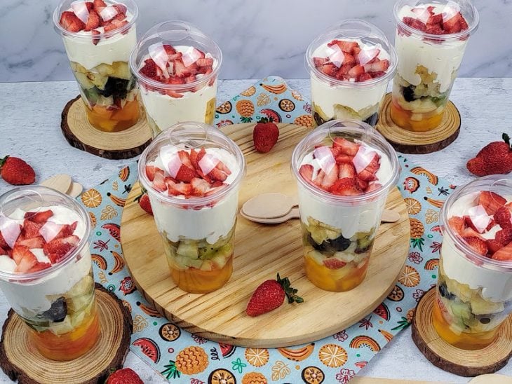 Uma bancada com salada de futas gourmet no pote.