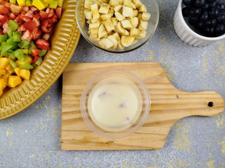 Pote com creme adicionado sobre as frutas.