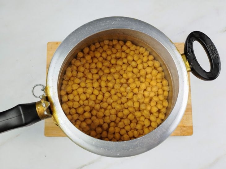 Grão de bico em uma panela de pressão com água e sal.