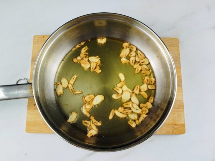 Alho fritando em uma panela com azeite.
