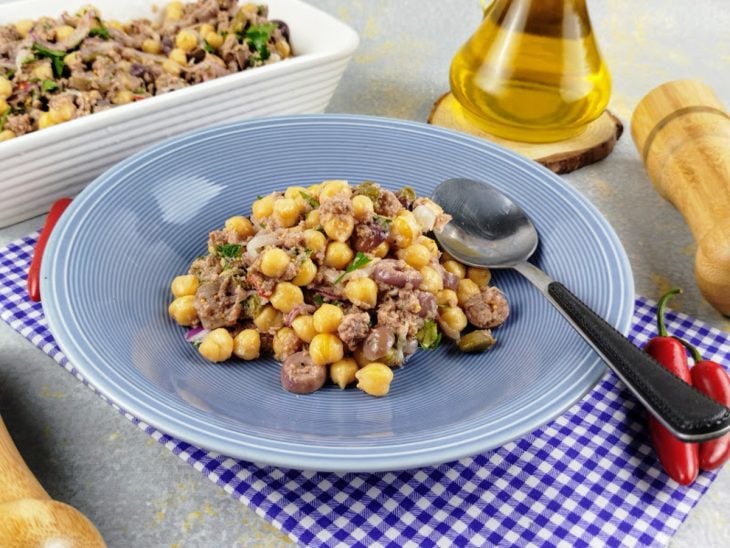Porção da salada de grão-de-bico com atum pronta para consumo em um prato.