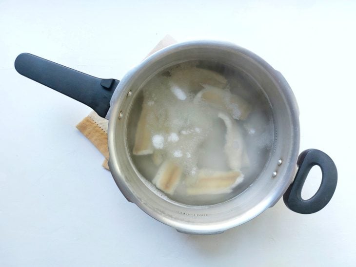 Bacalhau sendo cozido na panela de pressão.