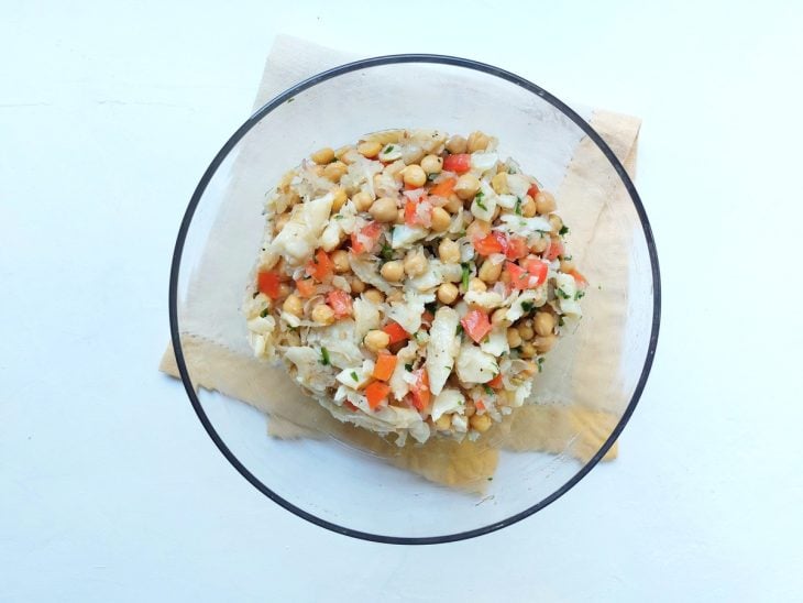 Ingredientes da salada de grão-de-bico com bacalhau misturados na tigela.