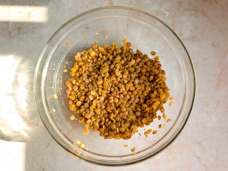 Lentilha temperada com sal e cominho numa tigela de vidro redonda.