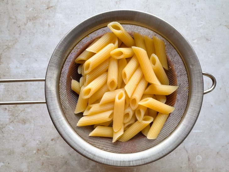 Macarrão sendo cozido em água fervente com sal.