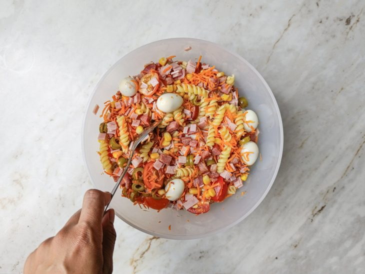 Ingredientes colocados na tigela com macarrão.