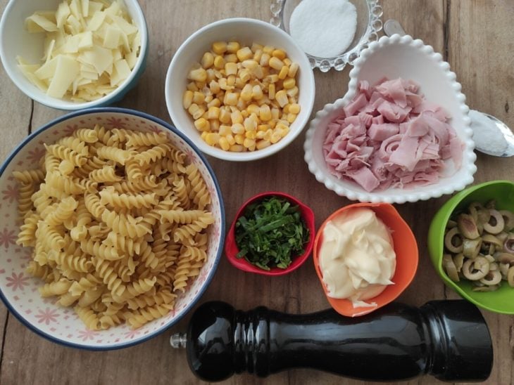 Ingredientes para a receita de macarrão com presunto separados em uma bancada.
