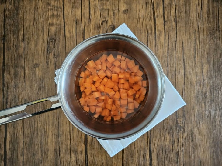 Panela com água e cenouras picadas.