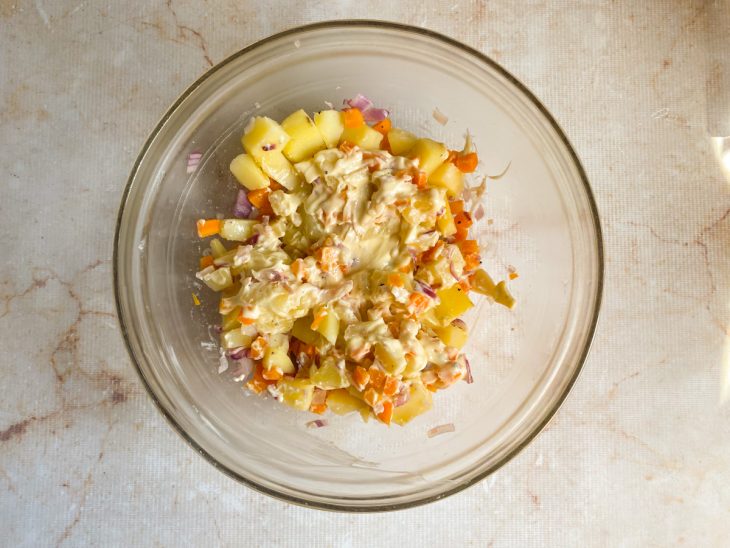 Numa tigela, vegetais assados misturados a maionese.
