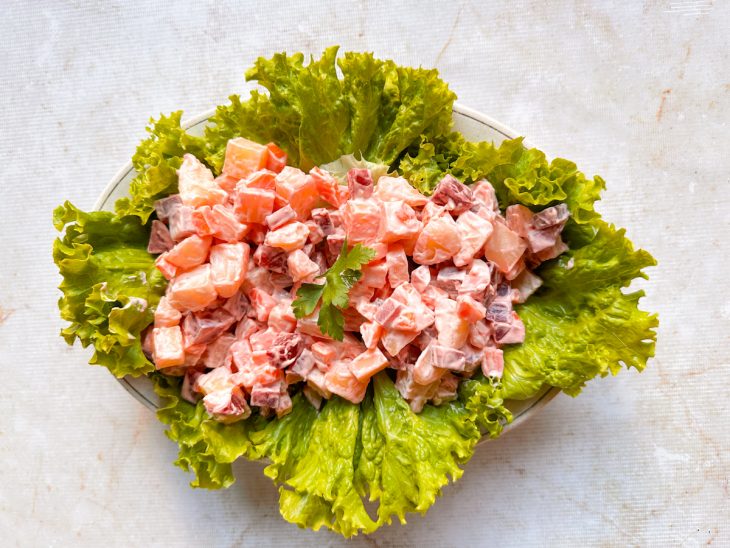 Salada de maionese acomodada sobre as folhas de alface.