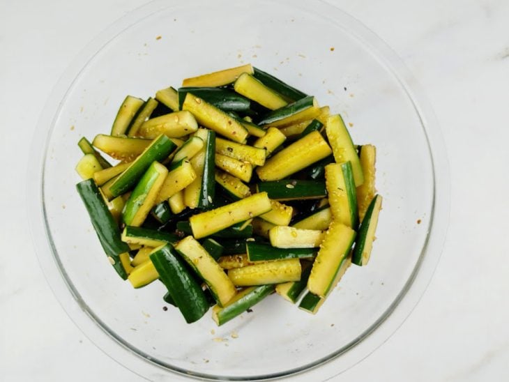 Tigela de vidro com os pepinos, vinagre, shoyu e pimenta-do-reino misturados.