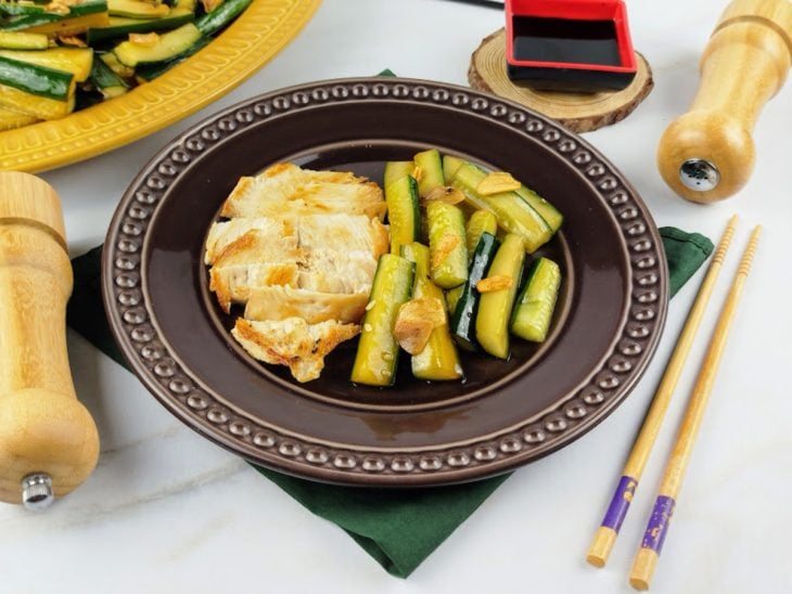 Prato com filé de frango frito e uma porção da salada de pepino.
