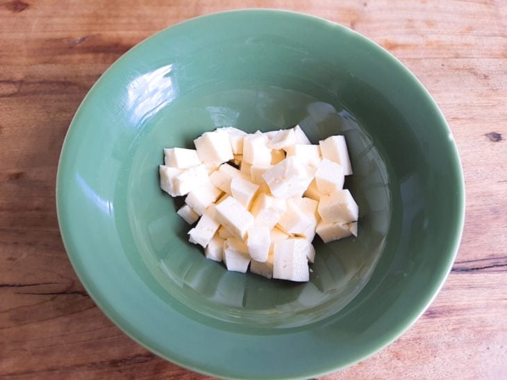 Uma tigela com o queijo em cubos.