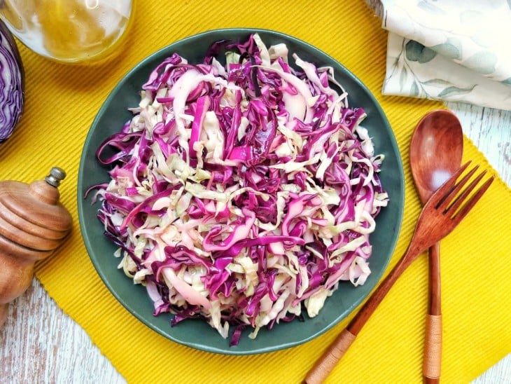 Um prato contendo salada de repolho branco e roxo.