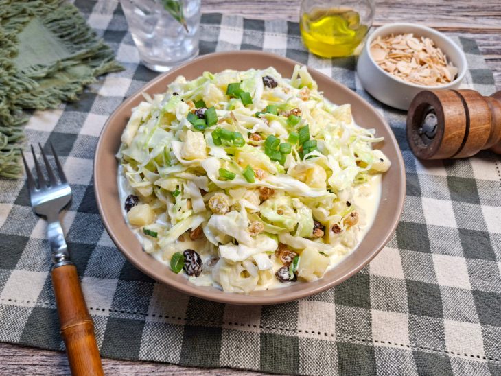 Salada de repolho com abacaxi, maionese e uva-passa pronta.