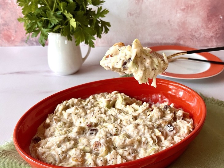 Salada de repolho com maça servido em refratário de cor vermelha.