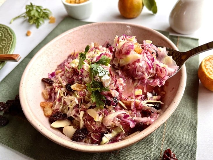 Salada de repolho cru sendo servida com uma colher.