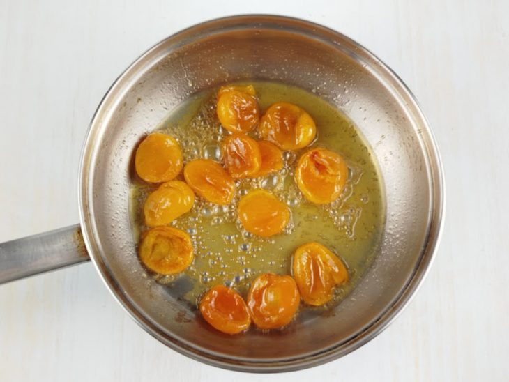 Damascos sendo dourados na frigideira com azeite e mel.