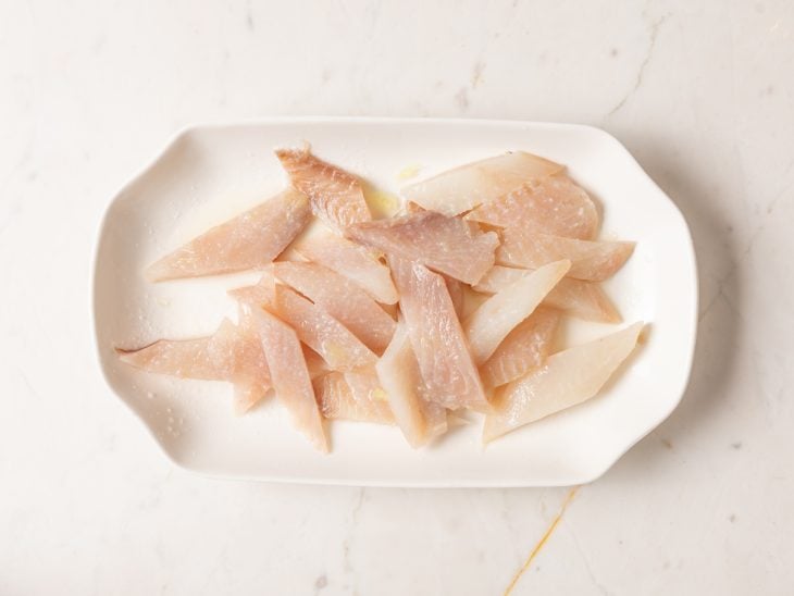 Um prato com o peixe temperado.