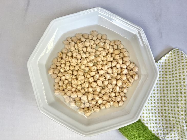 Um recipiente com água, bicarbonato de sódio e grão-de-bico.
