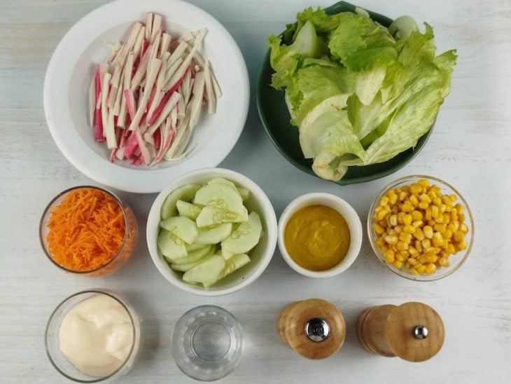 Ingredientes organizados na bancada com kani, legumes e molho.